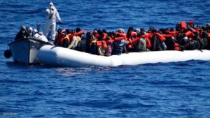 Migrants sit in their boat during a rescue operation of migrants by Italian Navy vessels in this March 18, 2016 handout picture provided by Marina Militare. REUTERS/Marina Militare/Handout via Reuters ATTENTION EDITORS - THIS PICTURE WAS PROVIDED BY A THIRD PARTY. REUTERS IS UNABLE TO INDEPENDENTLY VERIFY THE AUTHENTICITY, CONTENT, LOCATION OR DATE OF THIS IMAGE. FOR EDITORIAL USE ONLY. NOT FOR SALE FOR MARKETING OR ADVERTISING CAMPAIGNS. THIS PICTURE IS DISTRIBUTED EXACTLY AS RECEIVED BY REUTERS, AS A SERVICE TO CLIENTS.